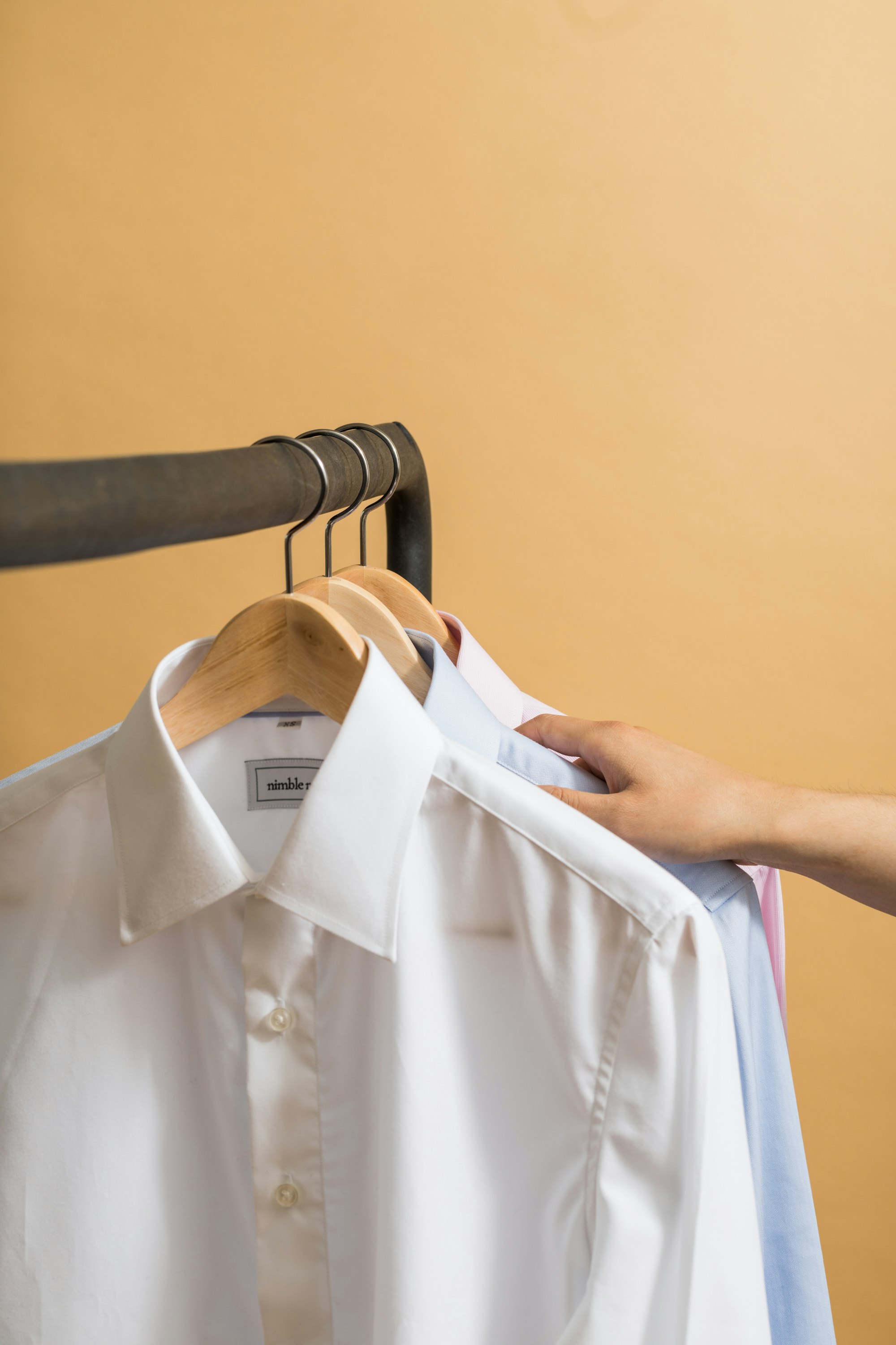 Sunlit shirts hanging on a quiet rack